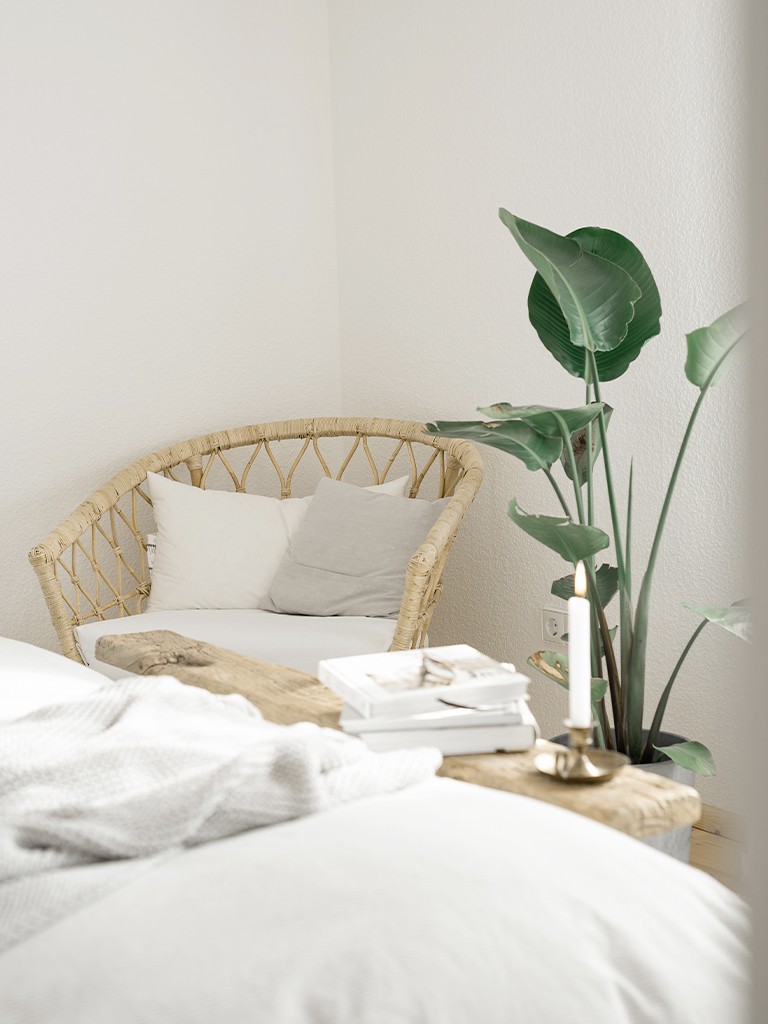 Schlafzimmer Makeover hell und gemütlich Korbsessel mit Grünpflanze